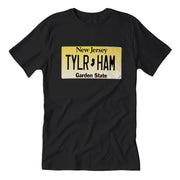 Black crew neck t-shirt with a print of a New Jersey license plate that reads 'TYLR HAM - Garden State'.